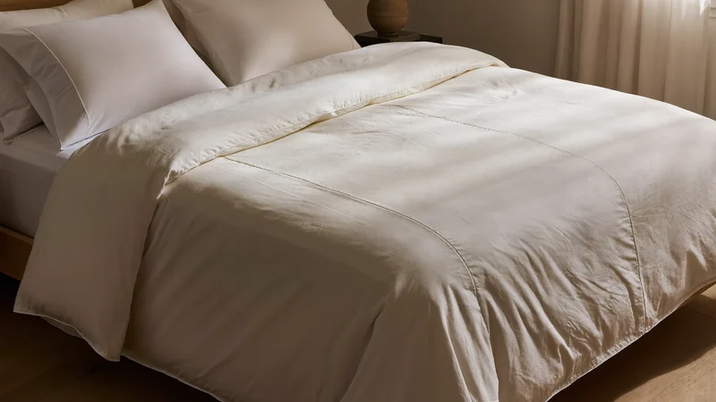 Weisses Percale-Bettbezug-Set auf einem gemachten Bett mit klaren Falten